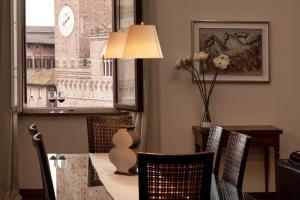 a dining room with a table and chairs and a clock at Palazzo Giorgi in Siena