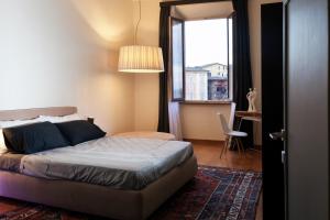 - une chambre avec un lit et une grande fenêtre dans l'établissement Palazzo Giorgi, à Sienne