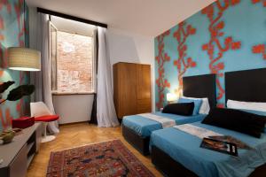 a hotel room with two beds and a window at Palazzo Giorgi in Siena