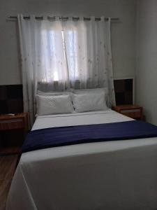 a bedroom with a large bed with a window at Pousada Vilarejo de Minas in Itapeva