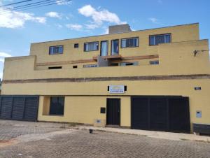 a yellow building with a sign on the side of it at GV Apartamentos-2qt-area central nobre- ar cond- in Governador Valadares