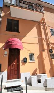 a building with a red umbrella over a door at La Rosatea Rooms in Monreale