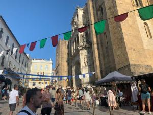 eine Gruppe von Menschen, die in einer Straße mit einem Gebäude stehen in der Unterkunft Serenata Hotel & Hostel Coimbra in Coimbra