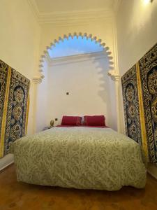 um quarto com uma cama grande e uma janela grande em Dar Tetuania em Tétouan