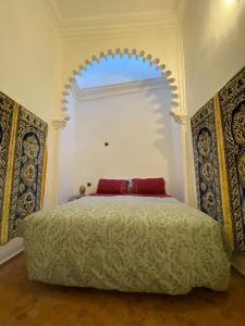 um quarto com uma cama grande e um arco por cima. em Dar Tetuania em Tétouan
