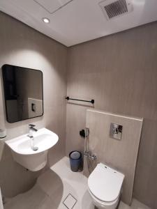 een badkamer met een wit toilet en een wastafel bij شقة فاخرة بالقرب من البوليفارد دخول ذاتي a14 in Riyad