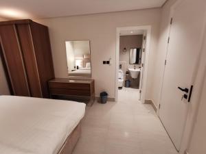 een slaapkamer met een bed en een badkamer met een spiegel bij شقة فاخرة بالقرب من البوليفارد دخول ذاتي a14 in Riyad