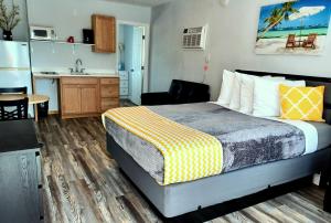 a hotel room with a bed and a kitchen at Johns Pass Beach Motel in St Pete Beach