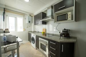 een keuken met een wasmachine en droger. bij THE PHOTOGRAFIC FLAT in Málaga