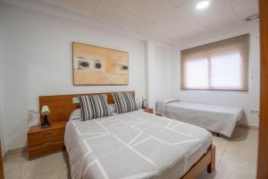 - une chambre avec un grand lit blanc et une fenêtre dans l'établissement THE PHOTOGRAFIC FLAT, à Malaga