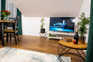 een woonkamer met een tv en een tafel bij Apartamenty ,,Górska Strefa'' Czorsztyn in Czorsztyn