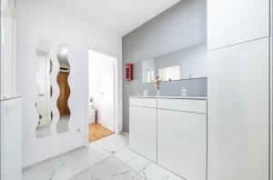 ein weißes Badezimmer mit Waschbecken und Spiegel in der Unterkunft Apartman Gold Oasis, self service check-in in Zagreb + 7 Fotos