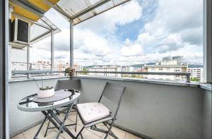 einen Balkon mit einem Tisch und Stühlen sowie Stadtblick in der Unterkunft Apartman Gold Oasis, self service check-in in Zagreb