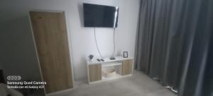 Ein Zimmer mit Fernseher und kleinem Tisch sowie einer Toilette in der Unterkunft Departamento 57 Parque San Martin in La Plata