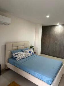 a bedroom with a large bed with blue sheets at Lindo apartamento cerca de Centro Comercial unico in Barranquilla