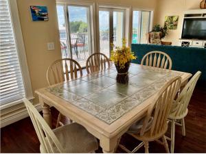 a dining room table with a vase of flowers on it at 102 6Th St S-Downstairs Home in Bradenton Beach