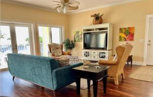 a living room with a blue couch and a tv at 102 6Th St S-Downstairs Home in Bradenton Beach