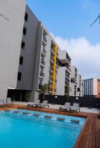een zwembad voor een gebouw met banken bij Iconic Millennial Umhlanga in Durban