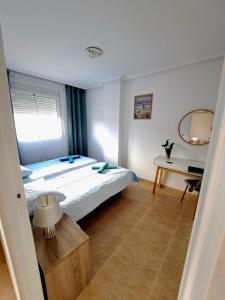 une chambre avec un grand lit et un miroir dans l'établissement Modern 2 bedroom apartment in the center of Torrevieja, à Torrevieja
