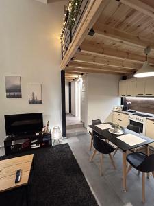 eine Küche und ein Wohnzimmer mit einem Tisch und Stühlen in der Unterkunft Celeste Loft in Tríkala