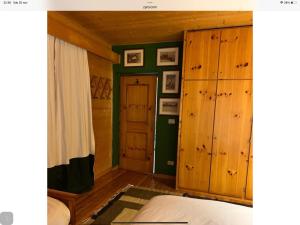 a bedroom with wooden walls and a bed and a door at Baita cavalese giardino esclusivo in Cavalese