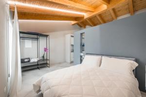 1 dormitorio con cama blanca y espejo en Borgo degli Ulivi, en Formigine