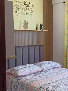 1 dormitorio con 1 cama con un cartel en la pared en Residencial Vista Bela, en Bombinhas