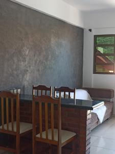 a dining room with a table and four chairs at Residencial Vista Bela in Bombinhas