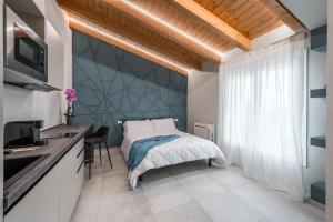 a bedroom with a bed with a large window at Borgo degli Ulivi in Formigine