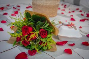 ein Strauß roter Rosen auf einem Tisch mit Herzen in der Unterkunft T24 Tinyhouse Container in Ibiúna
