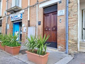 un bâtiment avec une porte en bois et des plantes devant lui dans l'établissement la casa sull arco, à Lucera