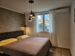 Un dormitorio con una cama con almohadas amarillas y una ventana en Deluxe Apartment near the Bridge, en Zadar