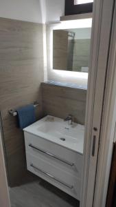 La salle de bains est pourvue d'un lavabo blanc et d'un miroir. dans l'établissement Marevita, à Trani