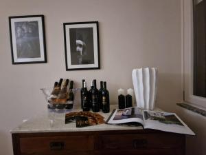 Guest House Canalis 17 في أوريستانو: طاولة مع زجاجات من النبيذ ومجلة