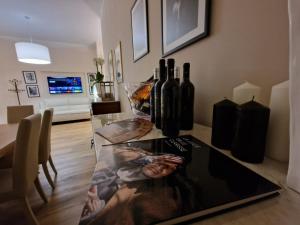 Guest House Canalis 17 في أوريستانو: طاولة زجاجية مع مجموعة من زجاجات النبيذ عليها