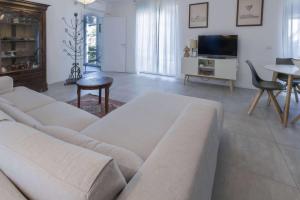 a living room with a couch and a tv at Alba House Malpensa Airport in Gallarate