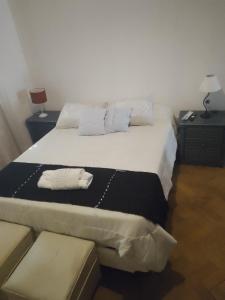 1 dormitorio con 1 cama con 2 toallas en El gallego en Concepción del Uruguay
