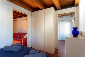 een slaapkamer met een blauw bed en een rode bank bij Comodo Apt Centrale in Treviso