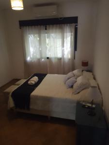 1 dormitorio con 1 cama grande y ventana en El gallego en Concepción del Uruguay