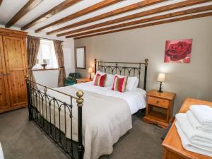 a bedroom with a large bed and a table at Orsedd Wen Cottage in Betws-y-coed