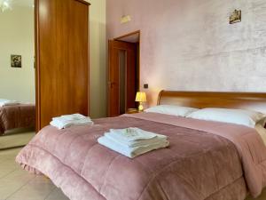 - une chambre avec un lit et des serviettes dans l'établissement Free WI-FI- Vista mare e Vesuvio-Casa Laura, à Naples