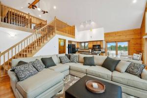 ein Wohnzimmer mit einem Sofa und einer Treppe in der Unterkunft Mountain Cabin overlook Boyne near Nubs W/ Hot Tub in Harbor Springs