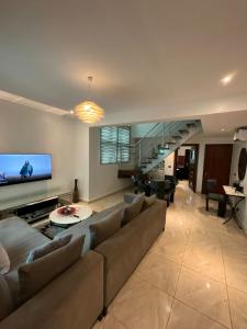 a living room with a large couch and a staircase at Blue Bell Suites in Lekki