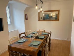a dining room with a table with chairs and a mirror at Pause En Seine- Appartement en duplex in Caudebec-en-Caux