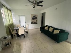 a living room with a green couch and a table at Mindanao # 842 in San Juan