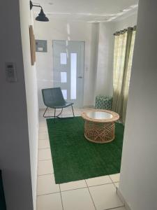 una habitación con una mesa y una silla sobre una alfombra verde en Mindanao # 842, en San Juan