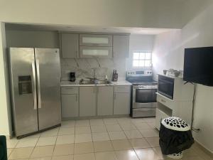 a kitchen with stainless steel appliances and white cabinets at Mindanao # 842 in San Juan