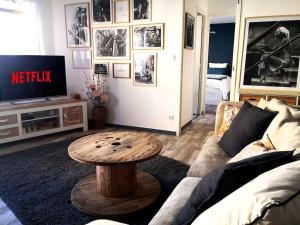 ein Wohnzimmer mit Sofa und Tisch in der Unterkunft Le Cocoon - SIPCO Immobilier - Netflix in Saint Lo + 1 Foto