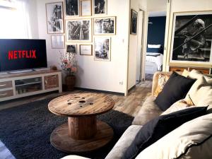 uma sala de estar com um sofá e uma mesa em Le Cocoon - SIPCO Immobilier - Netflix em Saint Lo