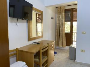 a room with a desk and a television on the wall at Hotel Martini in Vlorë